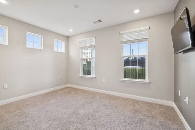 an empty room with windows flat screen tv and windows