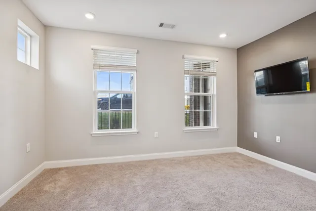 a view of an empty room with a window and a kitchen