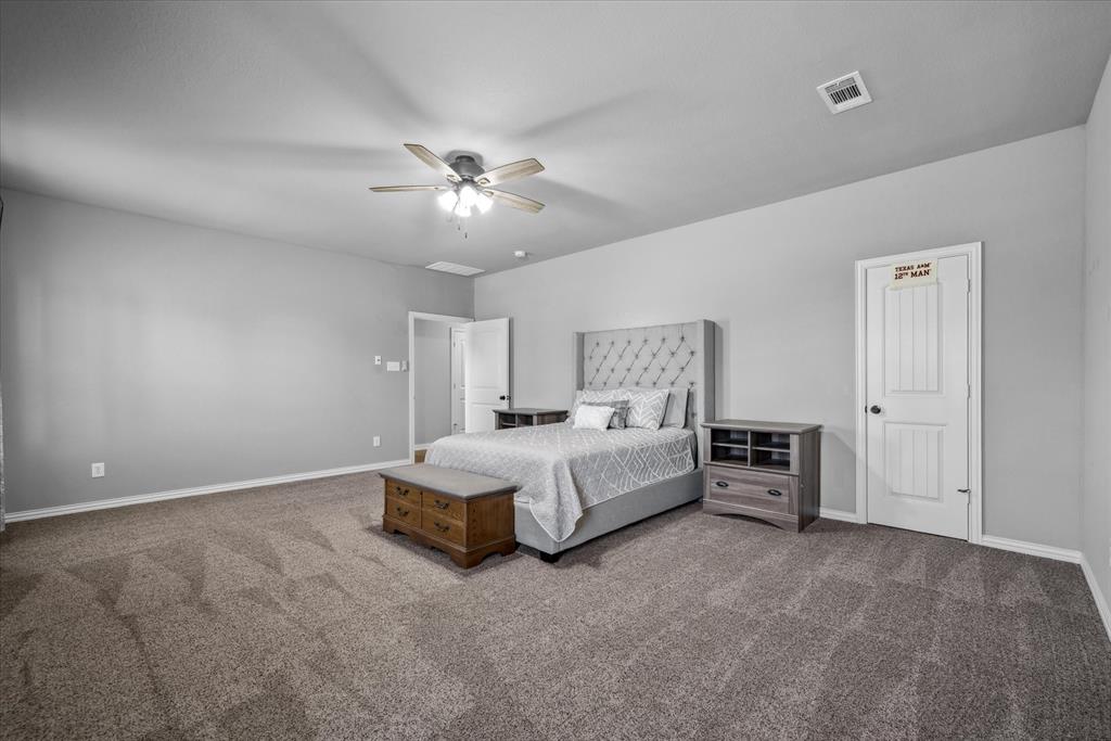 16159 County Road 347 Wills Point, TX 75169 - Photo 28 of 38 a spacious bedroom with a bed and a ceiling fan