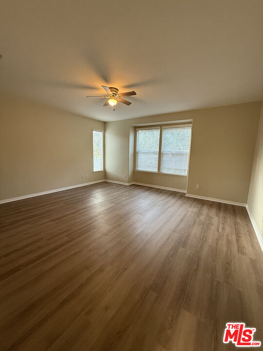 26003 Twain Place Stevenson Ranch, CA 91381 - Photo 11 of 12 an empty room with wooden floor and windows