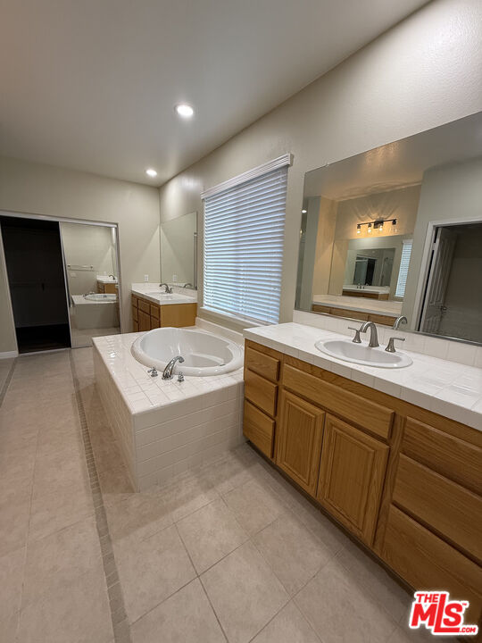 26003 Twain Place Stevenson Ranch, CA 91381 - Photo 12 of 12 a bathroom with a tub sink and mirror