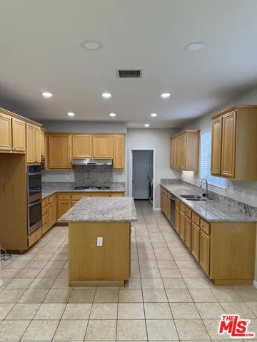 a large kitchen with stainless steel appliances granite countertop a large counter top and a stove