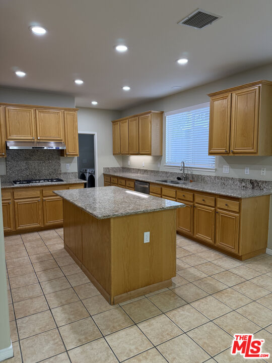 26003 Twain Place Stevenson Ranch, CA 91381 - Photo 5 of 12 a kitchen with stainless steel appliances granite countertop a sink and cabinets