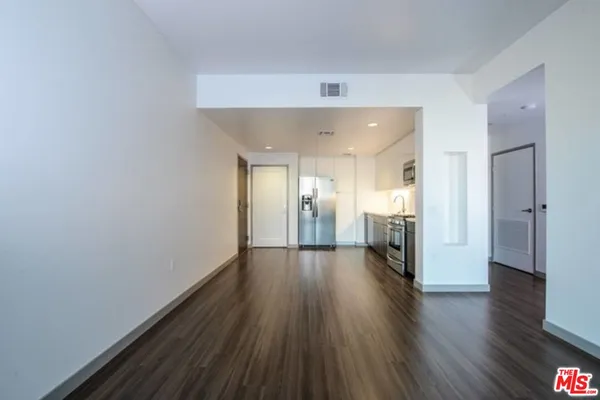 a view of a big room with wooden floor and a window