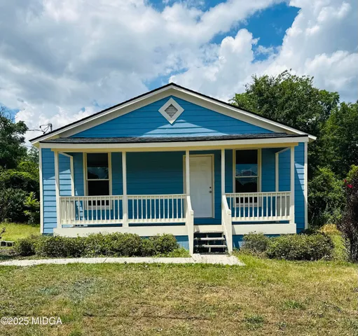 a front view of a house with a garden