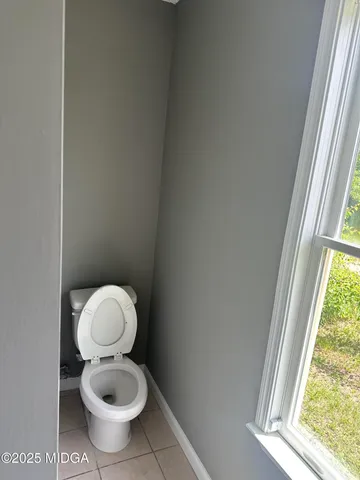 a white toilet sitting next to a window