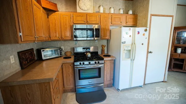 a kitchen with stainless steel appliances a refrigerator a stove a sink and a cabinets