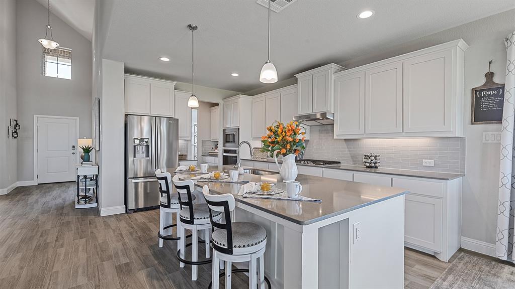 3280 Pier View Street Midlothian, TX 76065 - Photo 3 of 37 a kitchen with a table chairs refrigerator and cabinets