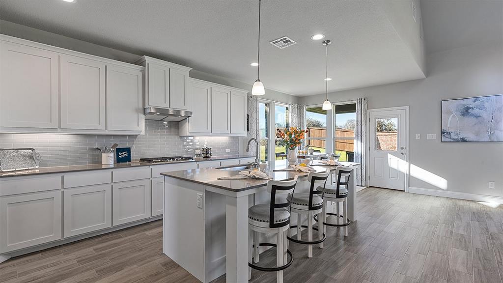 3280 Pier View Street Midlothian, TX 76065 - Photo 4 of 37 a kitchen with stainless steel appliances granite countertop a table chairs sink and cabinets