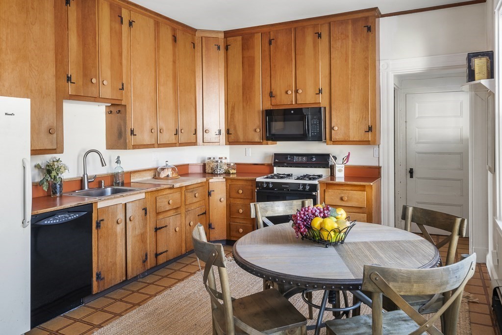 44 Mark Lee Road Needham, MA 02494 - Photo 11 of 33 a kitchen with stainless steel appliances kitchen island granite countertop a dining table and chairs