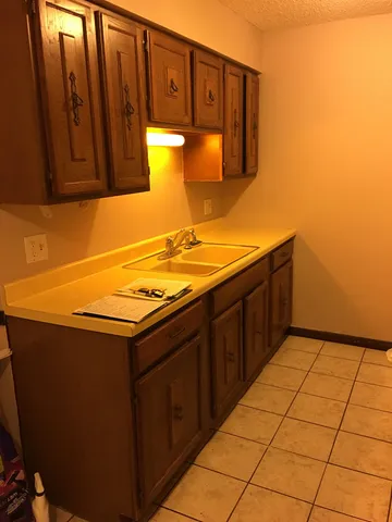 a kitchen with stainless steel appliances a sink cabinets and a window