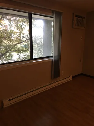 a view of a room with wooden floor and a window