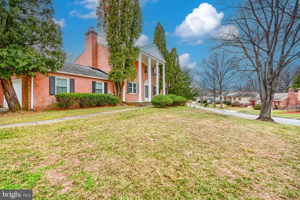 a front view of a house with a yard and trees