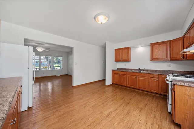 a kitchen with stainless steel appliances granite countertop a stove a sink and a microwave