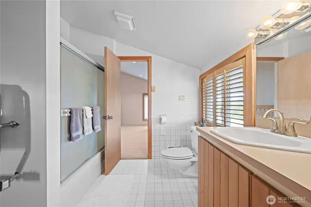 a spacious bathroom with a double vanity sink a toilet and a large mirror