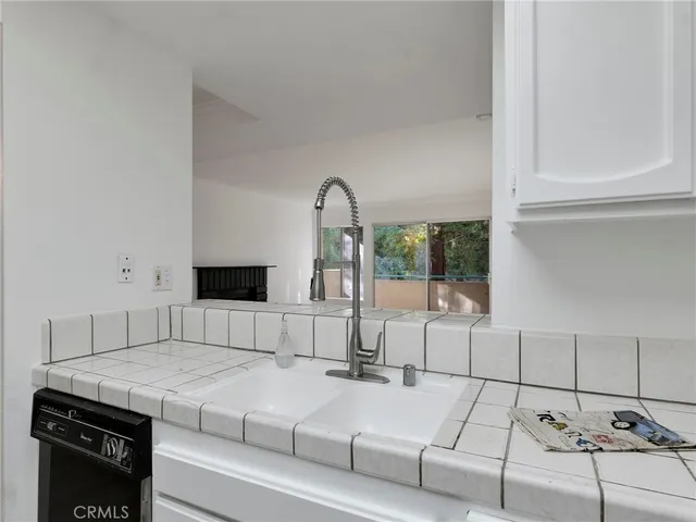 a kitchen with white cabinets stainless steel appliances and sink