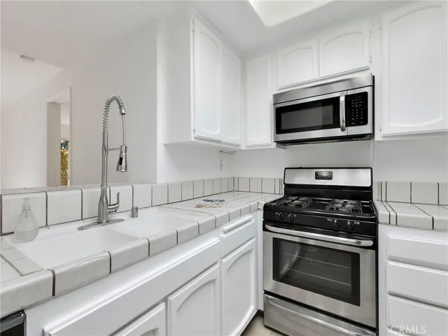a view of a kitchen with a sink dishwasher and a refrigerator