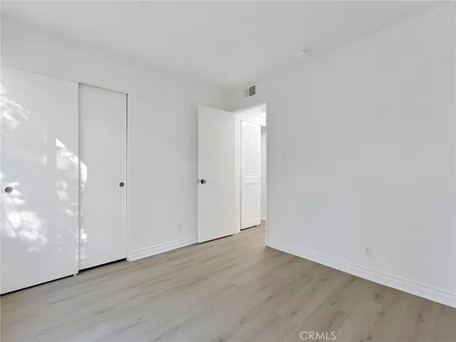 a view of a big room with wooden floor and doors
