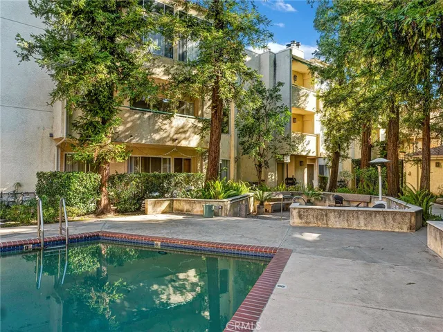an aerial view of residential house with outdoor space and trees all around
