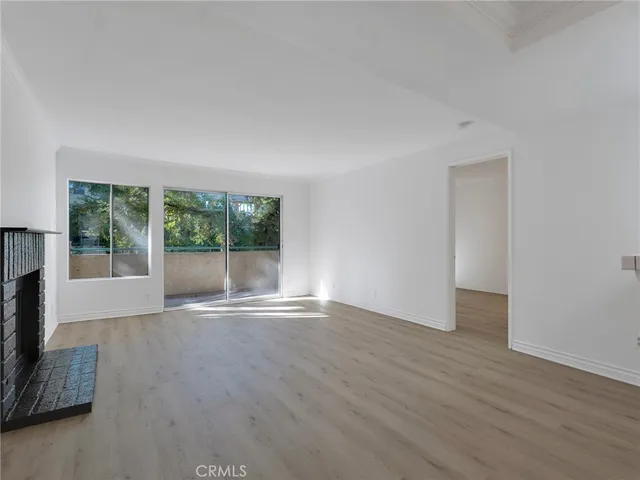 a view of a room with wooden floor and fireplace