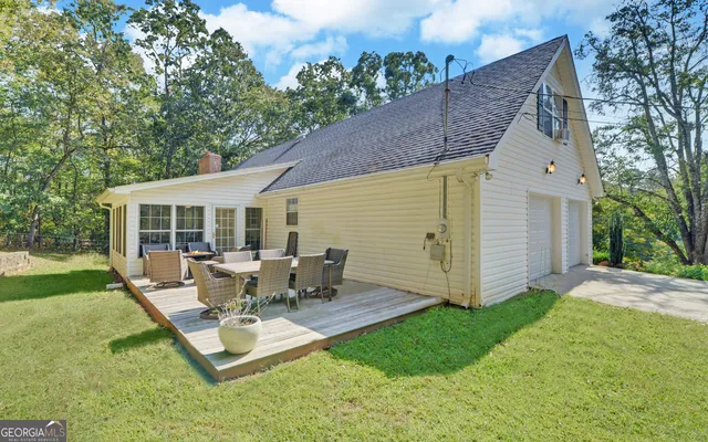 a backyard of a house with yard table and chairs