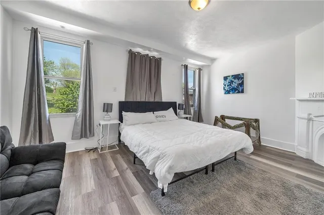a spacious bedroom with a bed and a flat tv screen on dresser