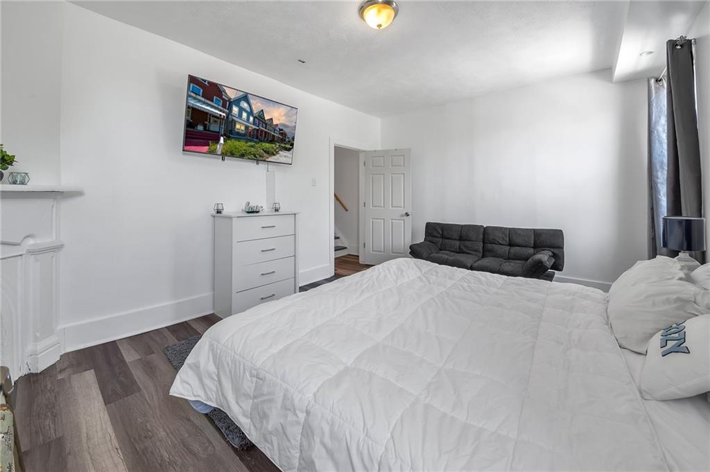 832 Adelaide Street Pittsburgh, PA 15219 - Photo 17 of 24 a bedroom with a bed and a flat screen tv