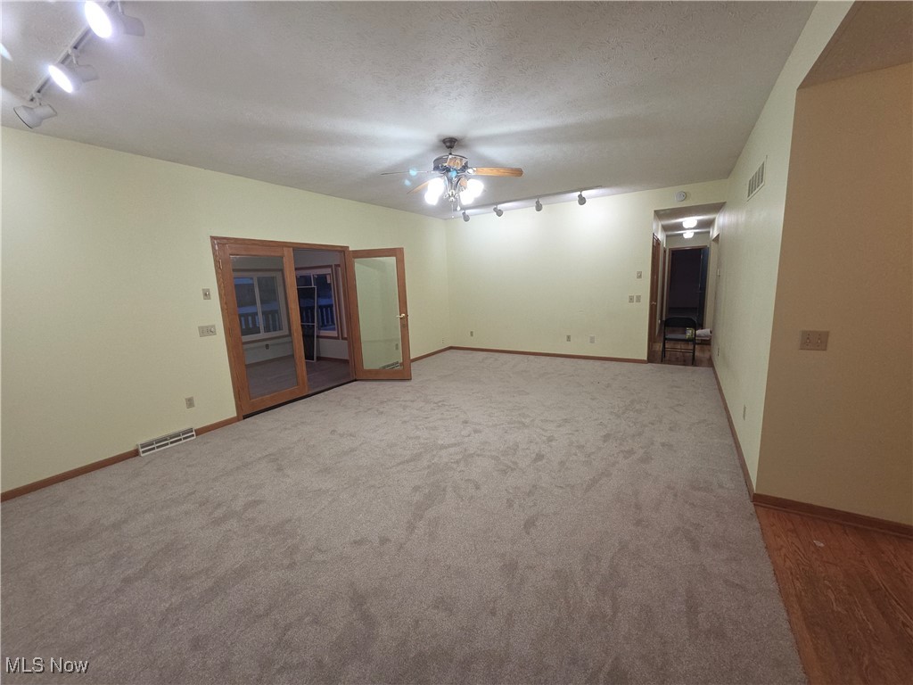2291 Armstrong Road Wooster, OH 44691 - Photo 4 of 23 Carpeted living room with track lighting, a ceiling fan, and a textured ceiling