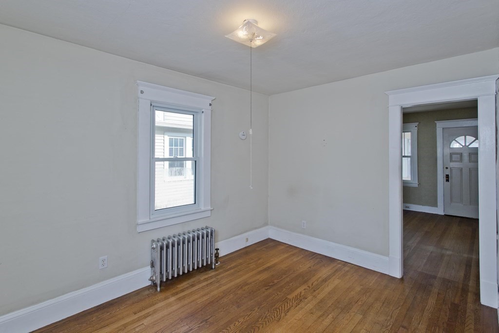 82 Redlands Street Springfield, MA 01104 - Photo 17 of 39 a view of an empty room with wooden floor and a window