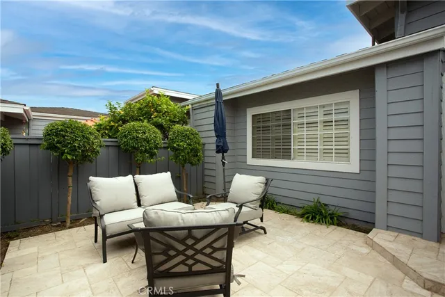a patio with table and chairs and potted plants