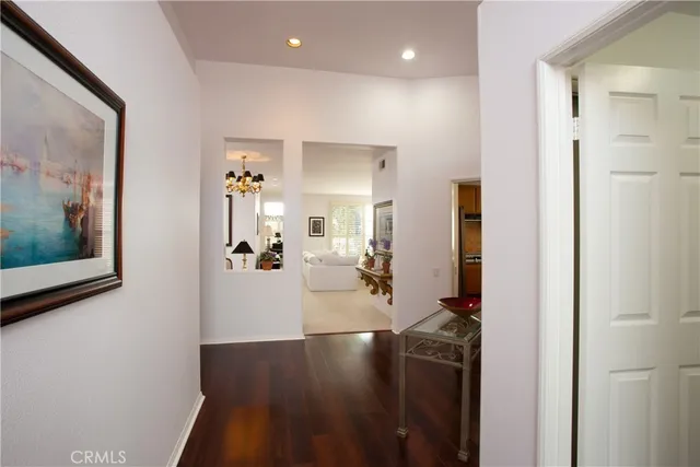 a view of a hallway with dining area and chandelier