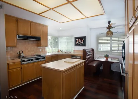 a kitchen with kitchen island granite countertop a sink appliances cabinets and a counter top space
