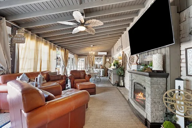 a living room with furniture a fireplace and a flat screen tv