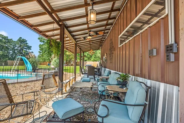 a view of a patio with table and chairs potted plants with wooden floor and fence