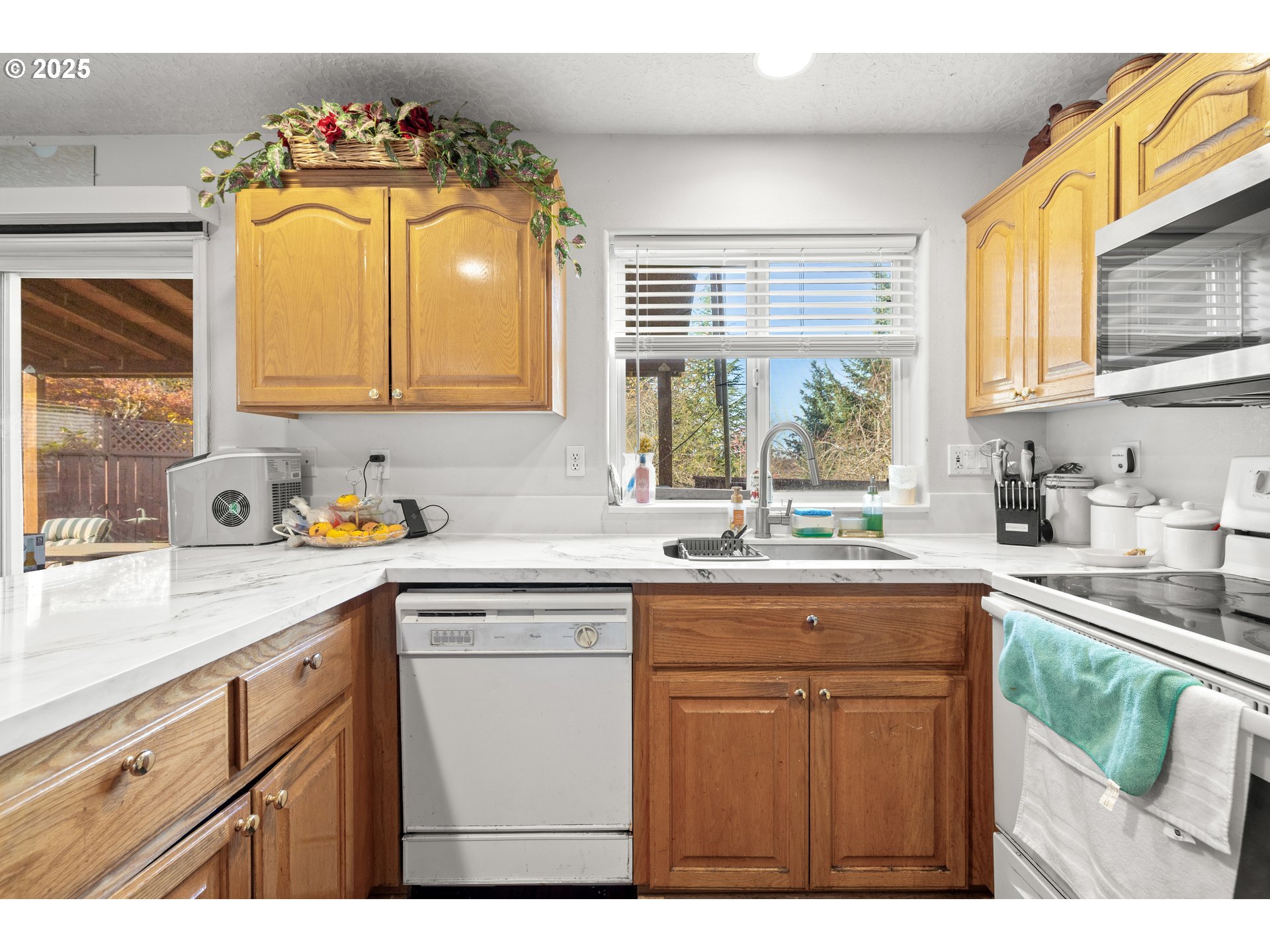 4235 Southeast Anderegg Loop Portland, OR 97236 - Photo 11 of 37 a kitchen with kitchen island granite countertop a sink and a white cabinets