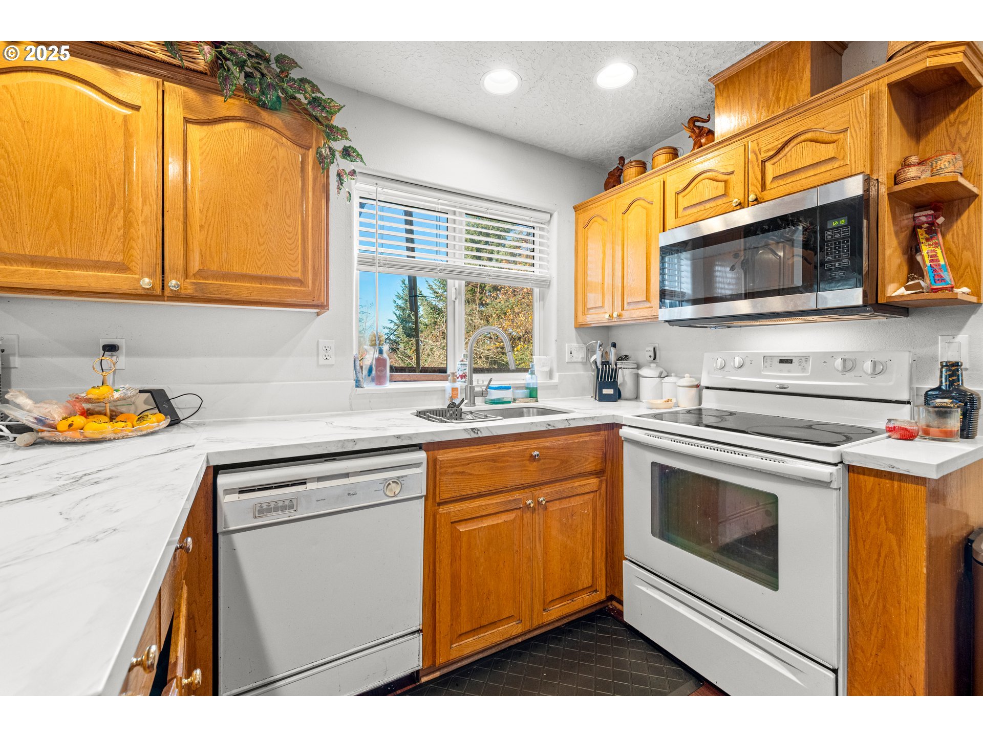 4235 Southeast Anderegg Loop Portland, OR 97236 - Photo 12 of 37 a kitchen with stainless steel appliances granite countertop a sink and cabinets with wooden floor