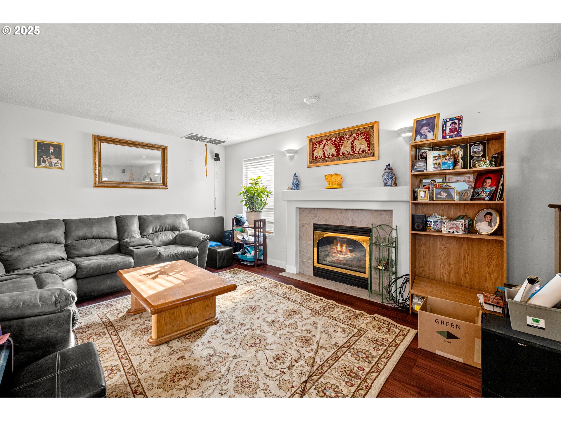 4235 Southeast Anderegg Loop Portland, OR 97236 - Photo 15 of 37 a living room with furniture a fireplace and a wooden floor