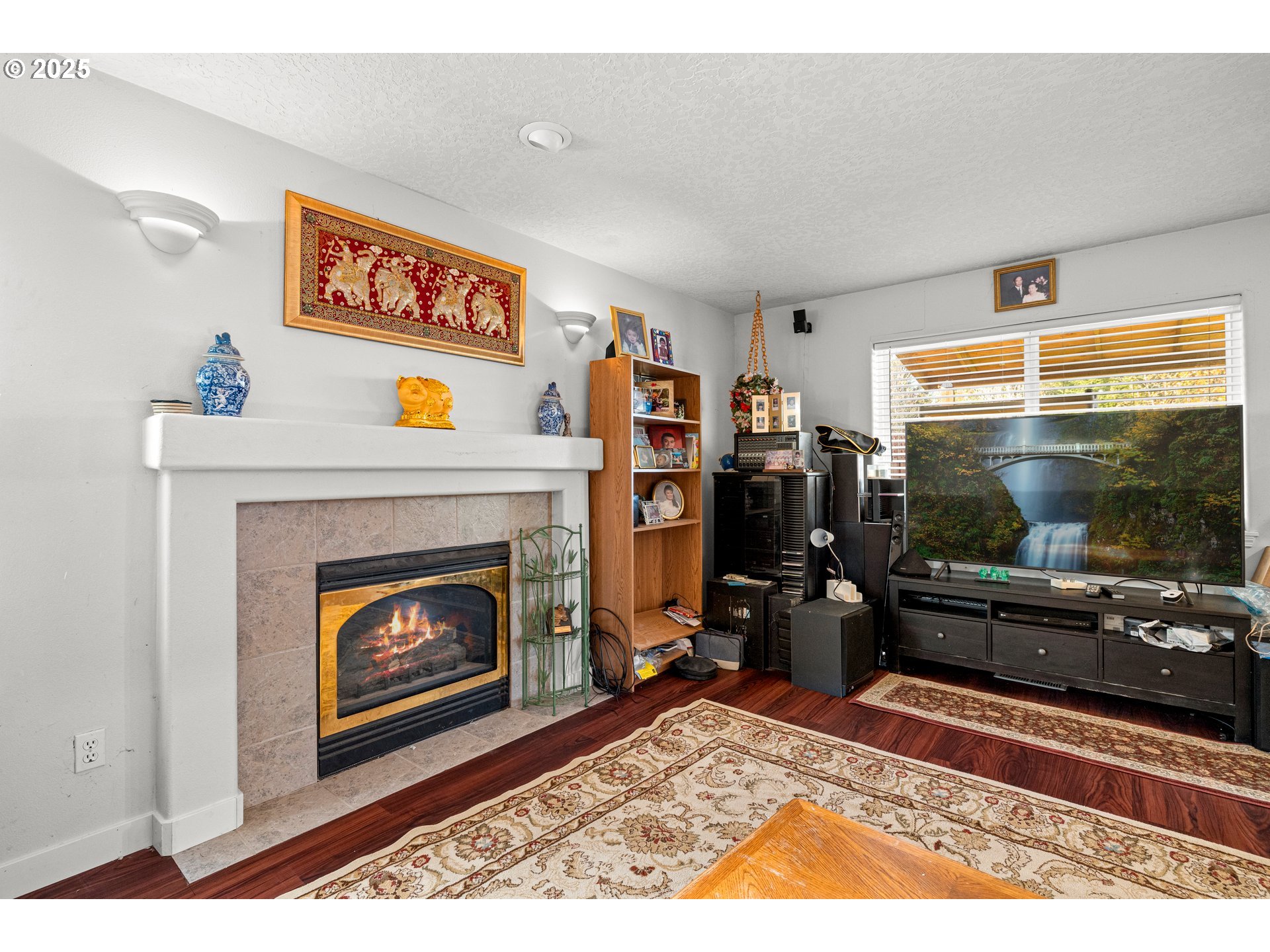 4235 Southeast Anderegg Loop Portland, OR 97236 - Photo 16 of 37 a living room with furniture a flat screen tv and a fireplace