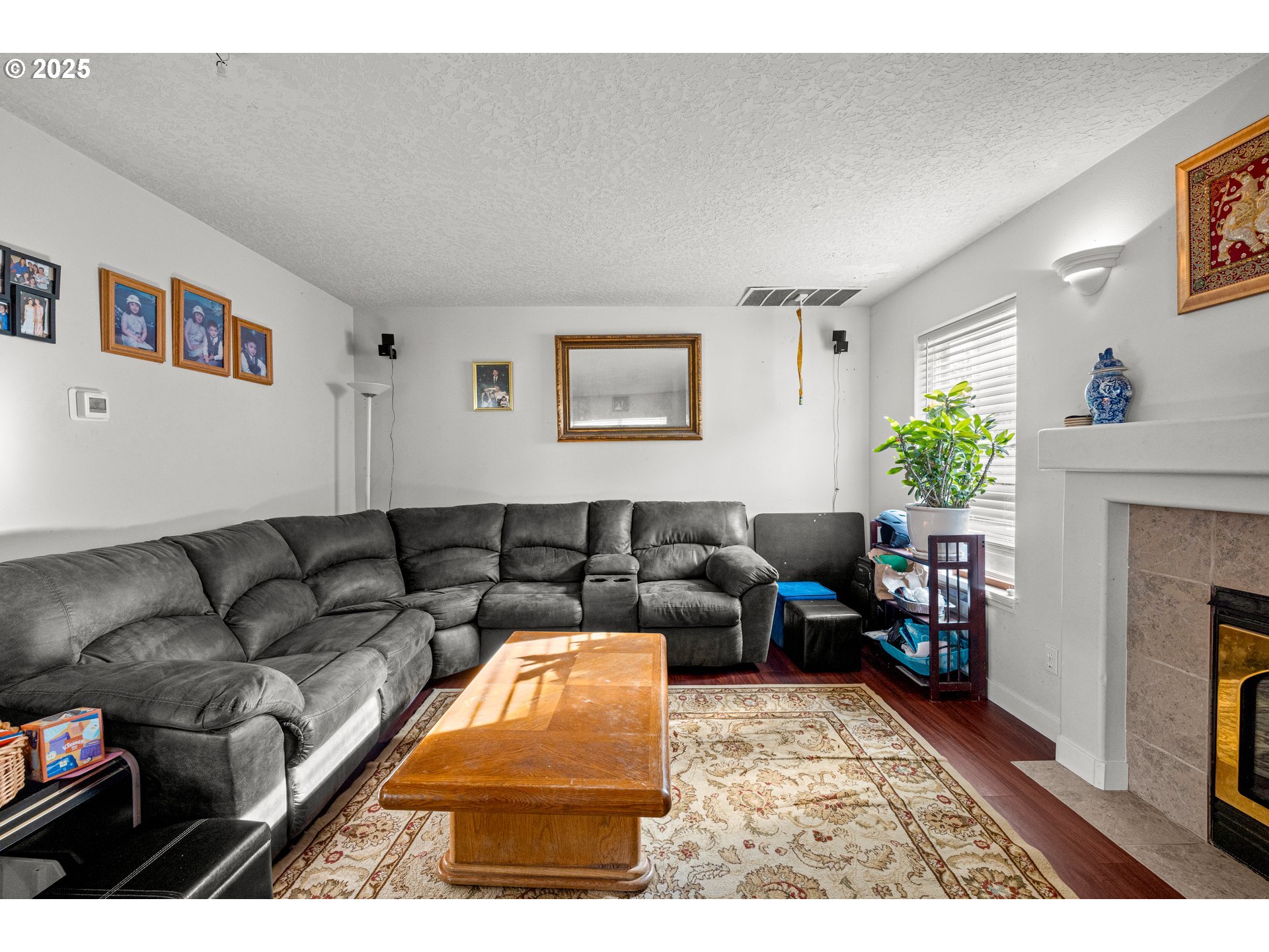 4235 Southeast Anderegg Loop Portland, OR 97236 - Photo 17 of 37 a living room with furniture a fireplace and a window