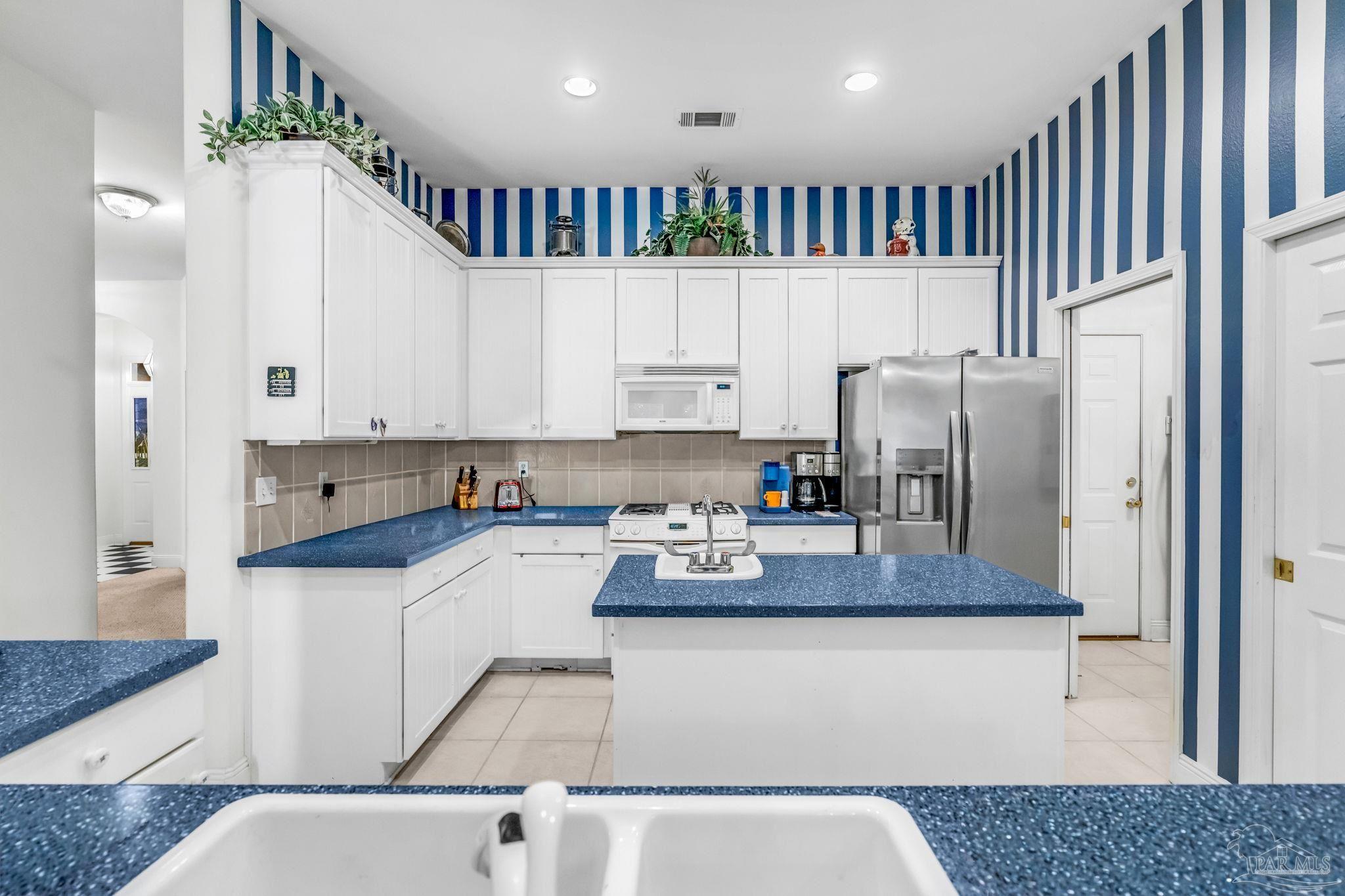 10149 Bittern Drive Pensacola, FL 32507 - Photo 18 of 56 a kitchen with stainless steel appliances granite countertop a refrigerator sink stove and white cabinets