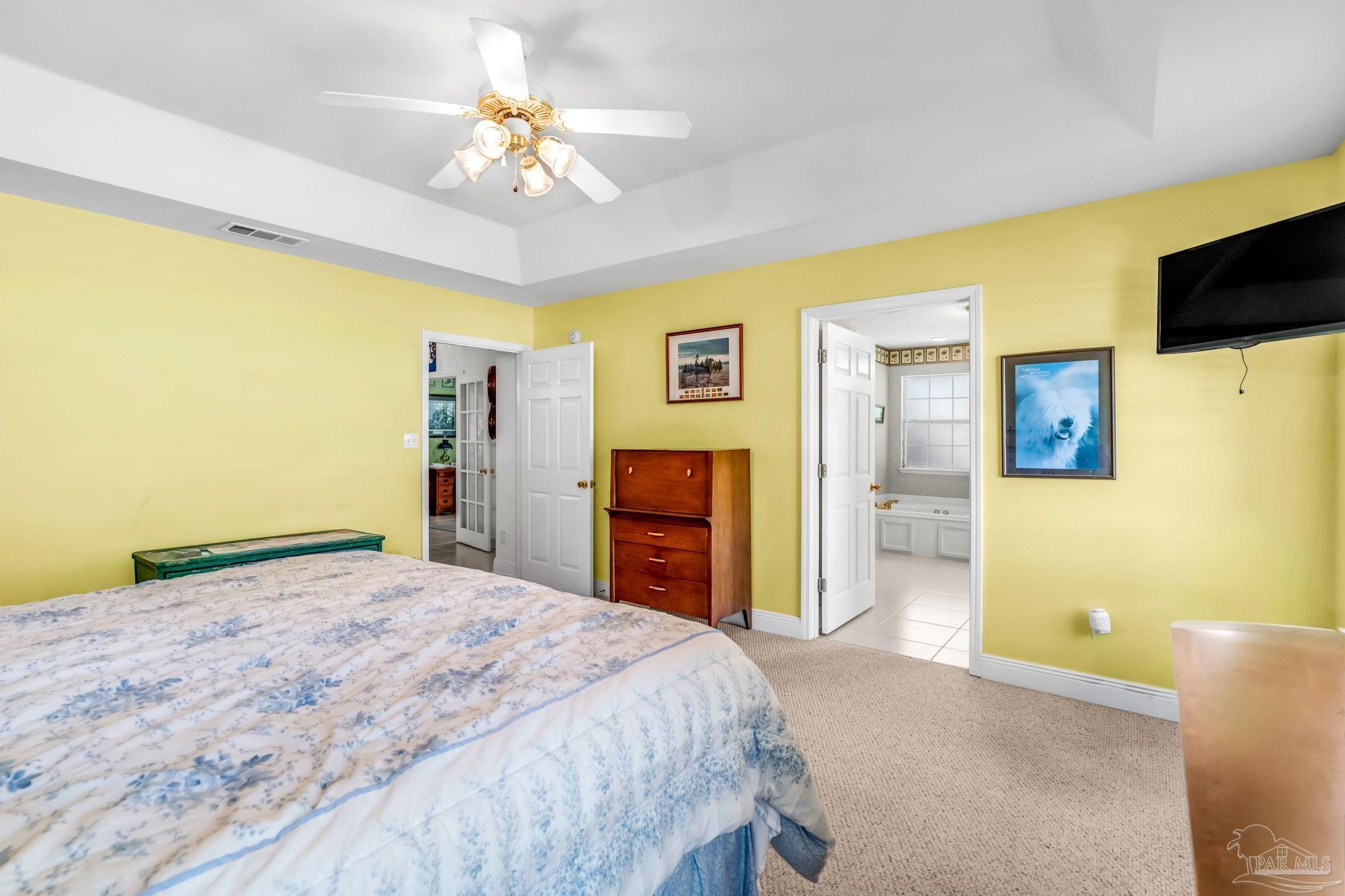 10149 Bittern Drive Pensacola, FL 32507 - Photo 24 of 56 a bedroom with a bed and a chandelier