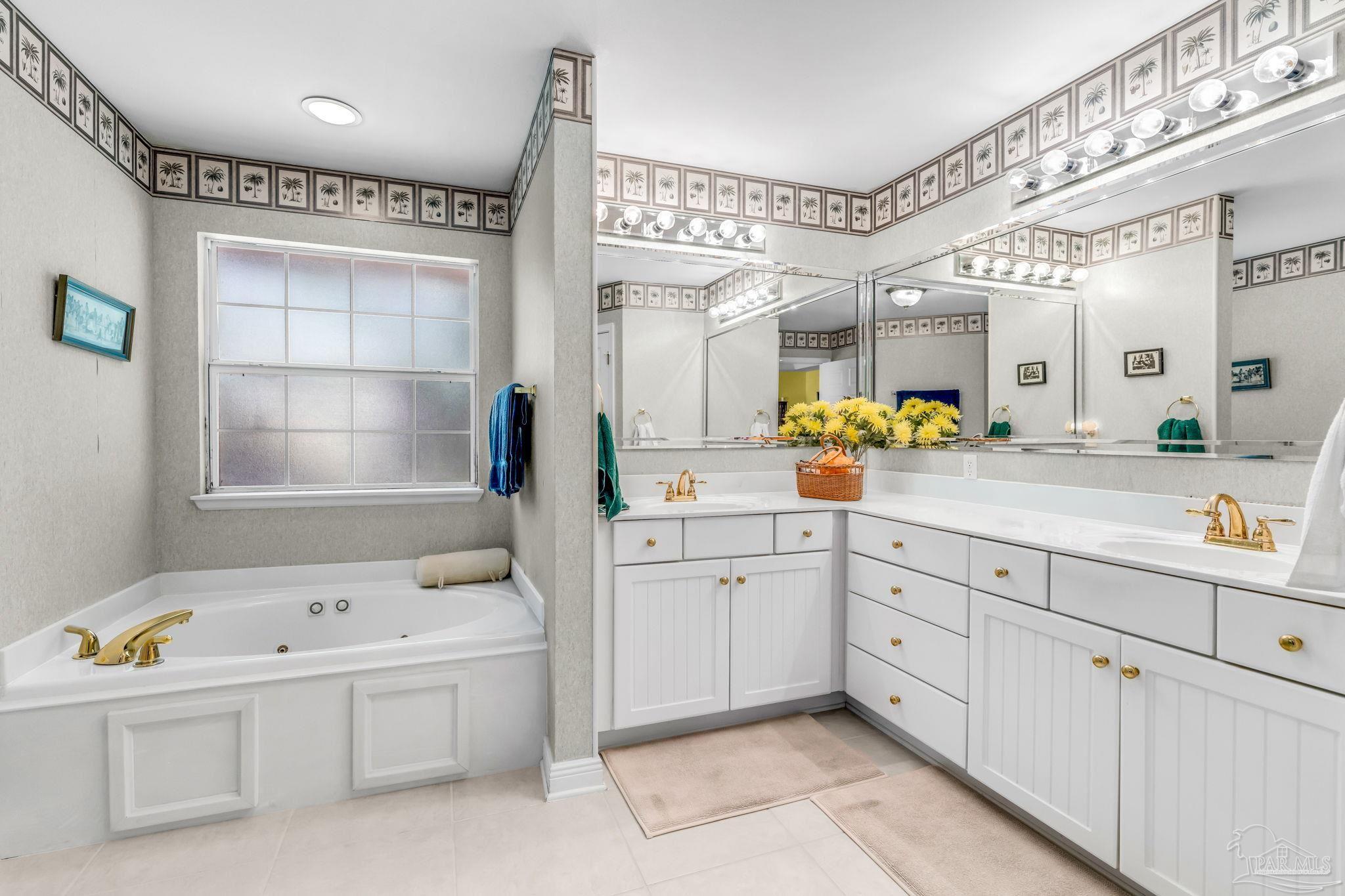 10149 Bittern Drive Pensacola, FL 32507 - Photo 26 of 56 a spacious en suite bathroom with a granite countertop tub and a window