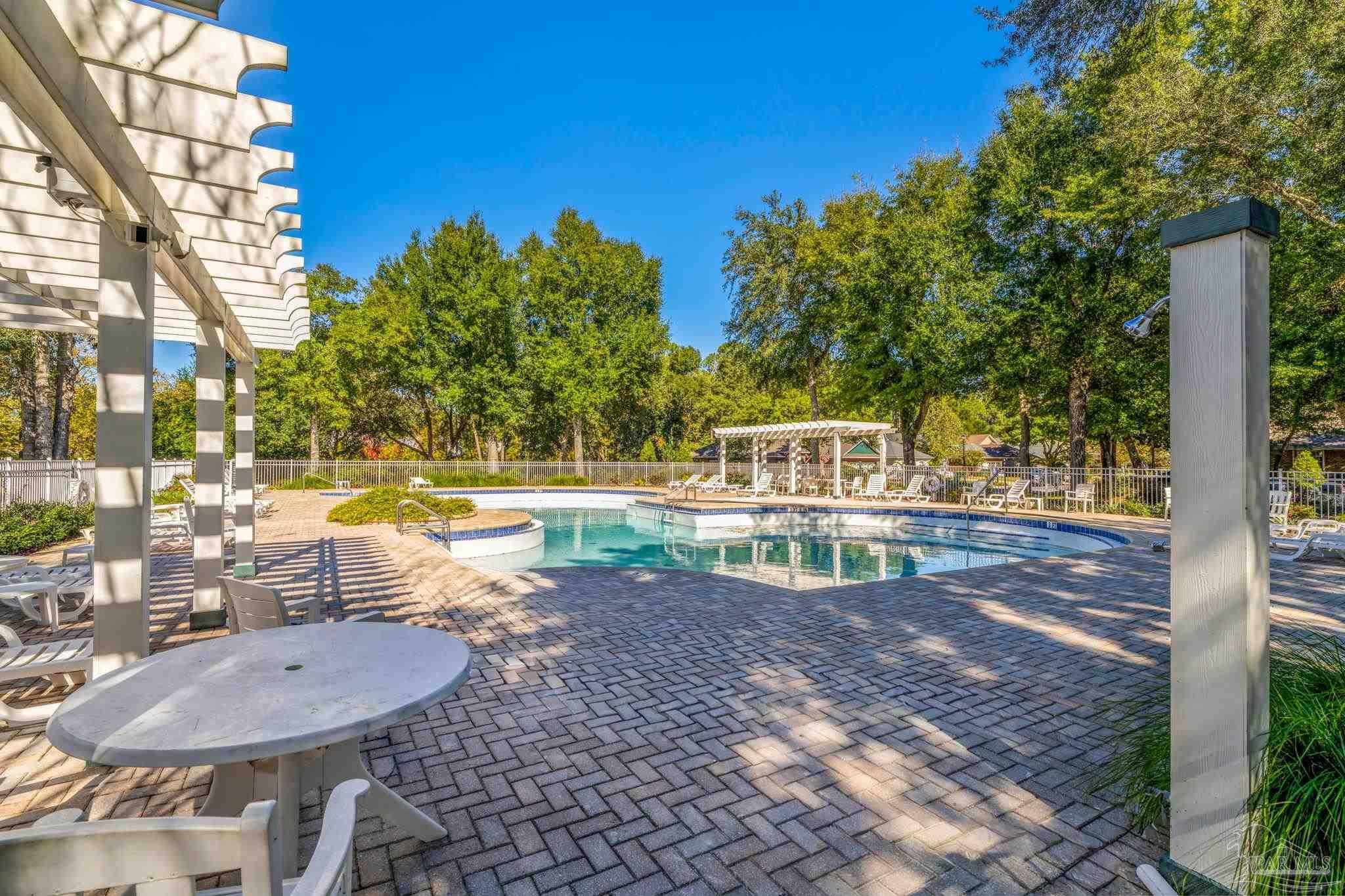 10149 Bittern Drive Pensacola, FL 32507 - Photo 46 of 56 a view of a swimming pool with a patio and a yard