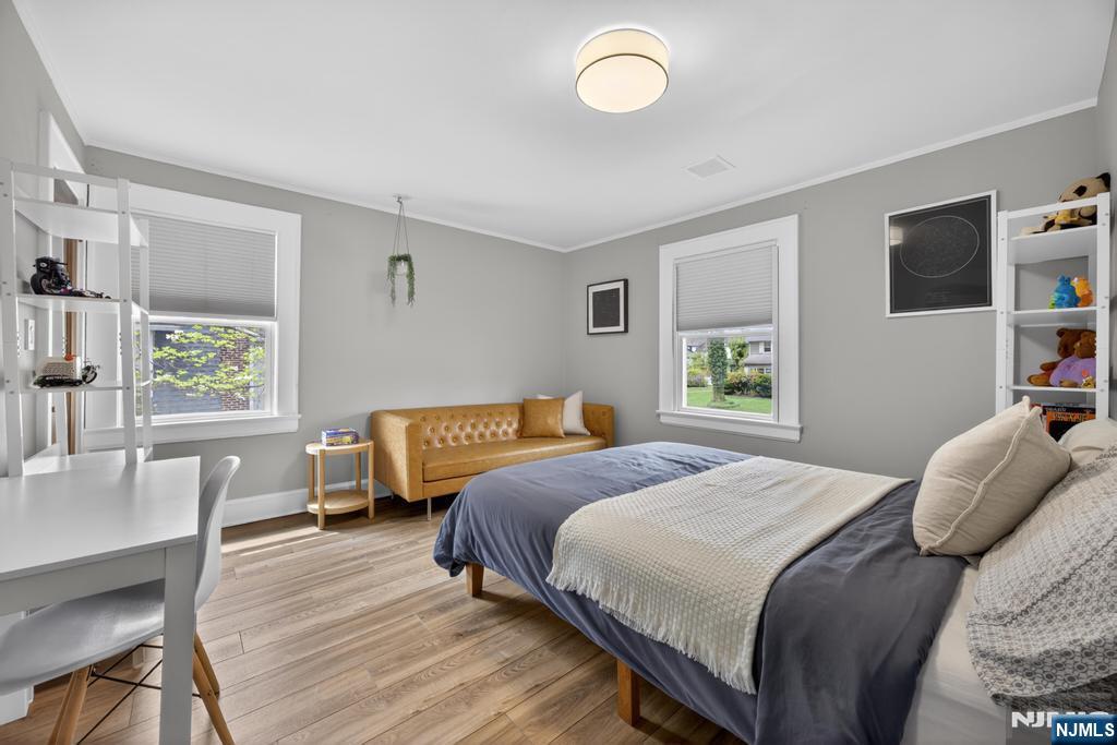 653 Ridgewood Avenue Bloomfield, NJ 07003 - Photo 13 of 27 a bedroom with a bed a bookshelf and a window