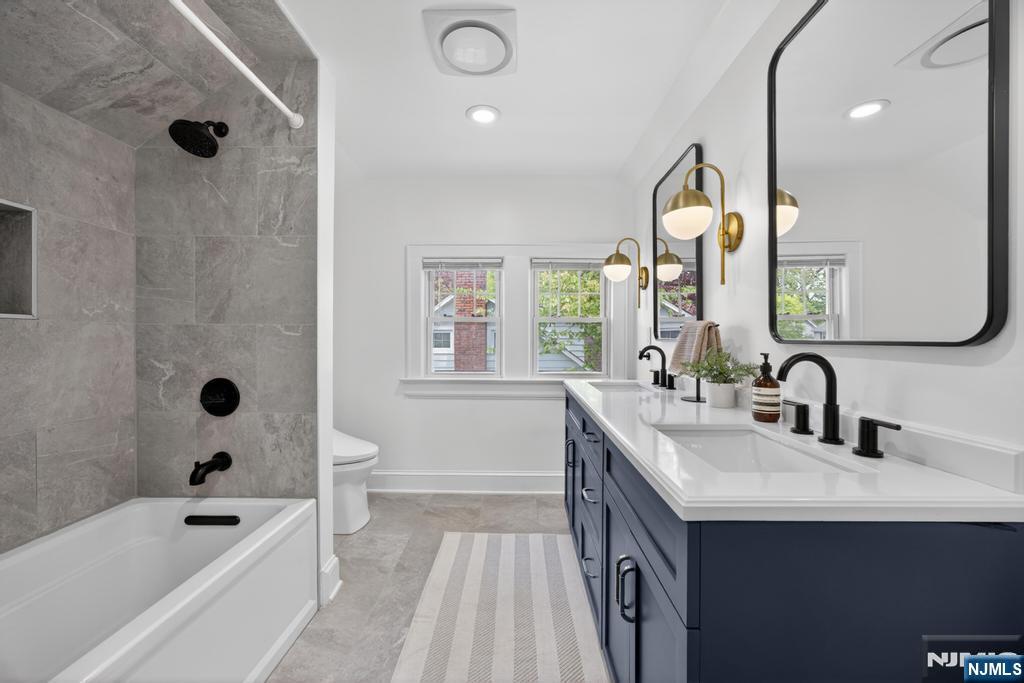 653 Ridgewood Avenue Bloomfield, NJ 07003 - Photo 17 of 27 a bathroom with a tub sink and mirror