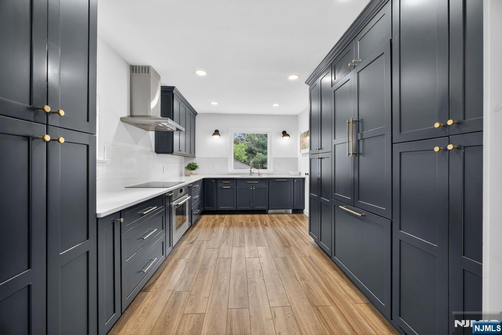 653 Ridgewood Avenue Bloomfield, NJ 07003 - Photo 7 of 27 a large kitchen with a refrigerator and wooden floor