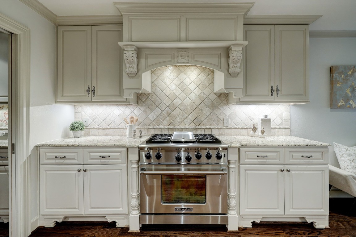 6599 Bayou Glen Road Houston, TX 77057 - Photo 21 of 41 Pictured is a closer view of the pro gas range with grill and lovely custom cabinetry and decorative tile.