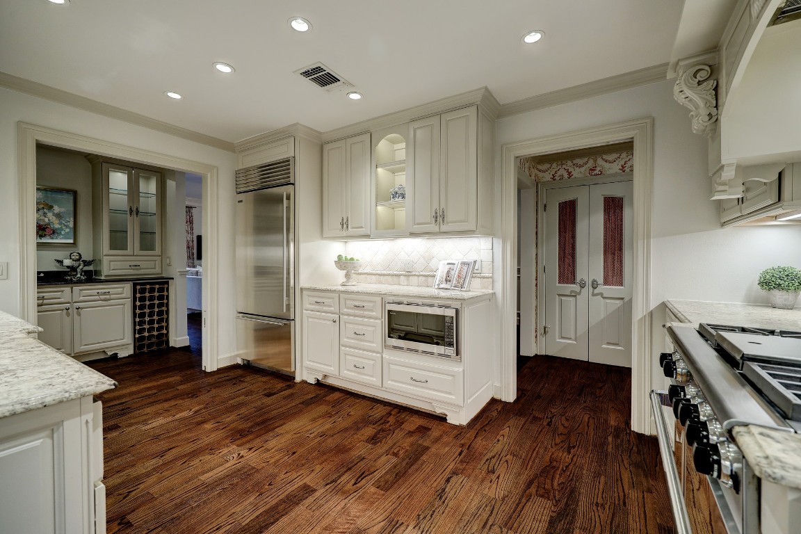 6599 Bayou Glen Road Houston, TX 77057 - Photo 23 of 41 From this view is another long counter with more storage, built-in microwave, accent lighted open shelving and the high end stainless SubZero built-in refrigerator!