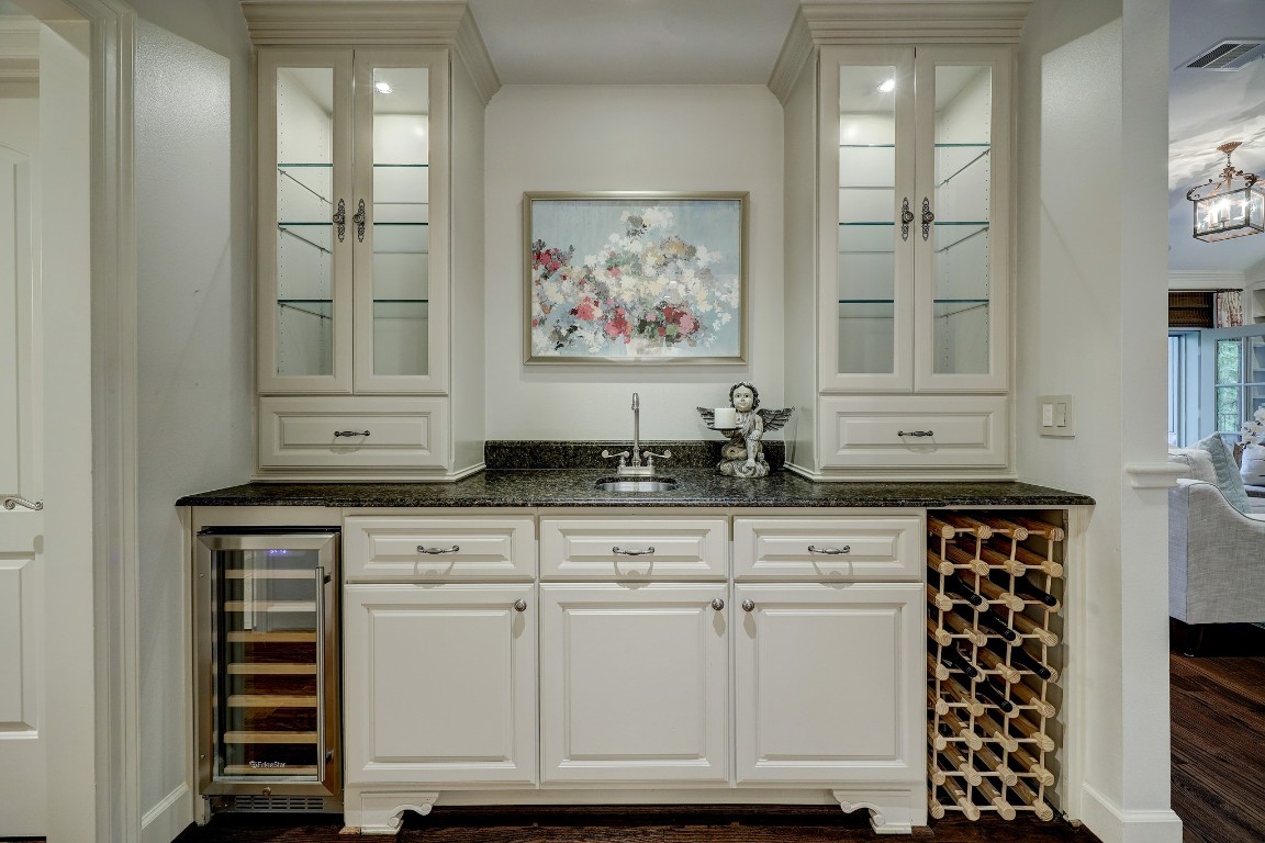 6599 Bayou Glen Road Houston, TX 77057 - Photo 24 of 41 Across the wide open entry to the kitchen is this fabulous wet bar. Fantastic for entertaining, it features a built-in wine cooler and wine rack, bar sink, wonderful storage with pull out drawers in lower cabinets and glass lighted upper cabinets.