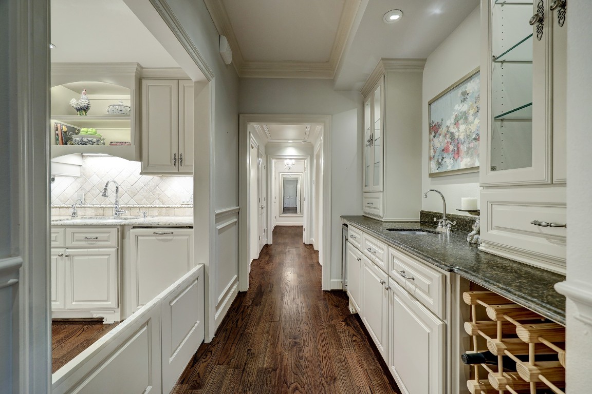 6599 Bayou Glen Road Houston, TX 77057 - Photo 25 of 41 View down the hall to the bedrooms. Notice the large opening to the kitchen and the custom made half pocket doors. Perfect for the pup? Wet bar is on the right.